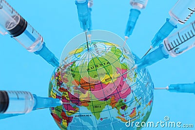 Abstract photo. A lot of syringes stuck into the layout of the earth. Stock Photo