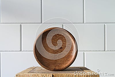 Abstract round wood bowl on wooden pillar against white background Stock Photo