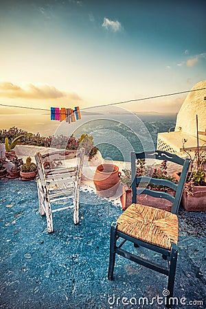 Abstract scene of two wooden chairs on a patio on Santorini. Stock Photo