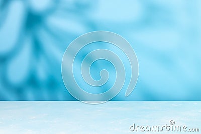 Abstract shadow on table top and blue wall background. Blurred backdrop with copy space Stock Photo