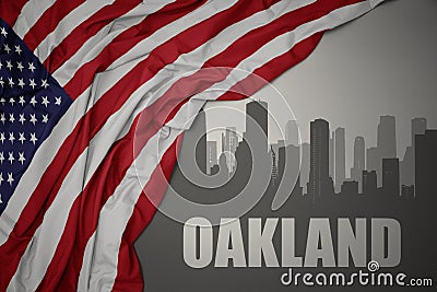 Abstract silhouette of the city with text Oakland near waving colorful national flag of united states of america on a gray Stock Photo
