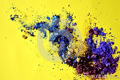 Abstract splash of blue and purple powder on yellow background Stock Photo