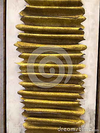 Abstract textured artwork with golden corrugated patterns arranged in parallel lines on a neutral white background, creating a Stock Photo