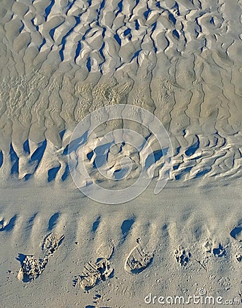 abstract textured sand with shapes due to the tide and the waves. Stock Photo