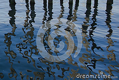 Abstract:Trails of Wooden Pier Reflections on Blue Water Stock Photo