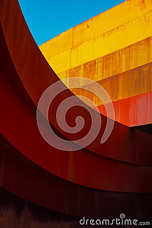 Abstract view of modern sculptural architecture with vibrant red and yellow curves. Stock Photo