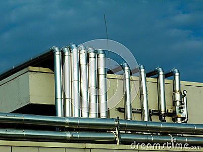 Abstract view of shiny stainless steel mechanical pipes on high roof Stock Photo