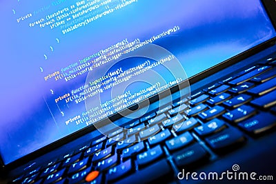 Abstract web developer background. Blue laptop screen with PHP code Stock Photo