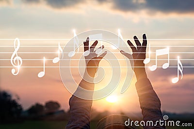 Abstract woman hands touching music notes on nature background, Stock Photo