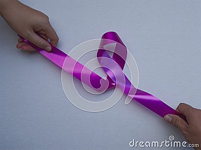 Abstract women hands and men hands pulling pink ribbons expressing breast cancer awareness day concept isolated pink background Stock Photo