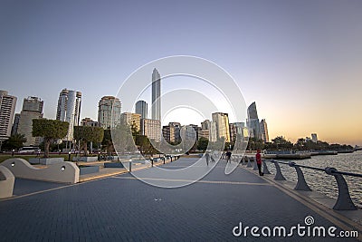 Abu Dhabi. United Arab Emirates: Abu Dhabi Corniche beachfront. people walk along the city embankment Editorial Stock Photo