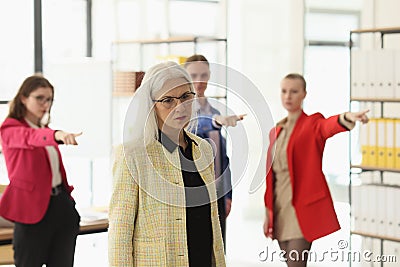 Abusive colleagues blame mature employee in company office Stock Photo