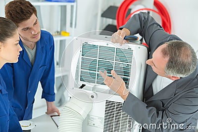 3 ac technicians repairing industrial air conditioning compressor Stock Photo