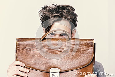 Academic style and business concept. Nerd with messy hair and confident look. Man hiding behind briefcase isolated on Stock Photo