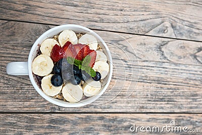 acai bowls with fresh fruit strawberry, blueberry, banana in white bowl on wooden table. Stock Photo