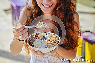 Acai bowl woman eating morning breakfast at cafe. Closeup of fruit smoothie healthy diet for weight loss with berries and oatmeal. Stock Photo