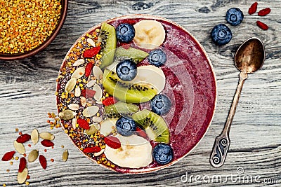 Acai breakfast superfoods smoothies bowl with chia seeds, bee pollen, goji berry toppings and fruits. Overhead. top view, flat lay Stock Photo