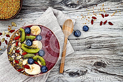 Acai breakfast superfoods smoothies bowl with chia seeds, bee pollen, goji berry toppings and fruits. Overhead. top view, flat lay Stock Photo