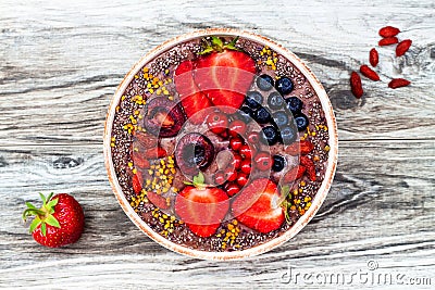 Acai breakfast superfoods smoothies bowl with chia seeds, bee pollen, goji berry toppings and peanut butter. Overhead Stock Photo