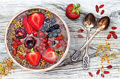 Acai breakfast superfoods smoothies bowl with chia seeds, bee pollen, goji berry toppings and peanut butter. Overhead Stock Photo