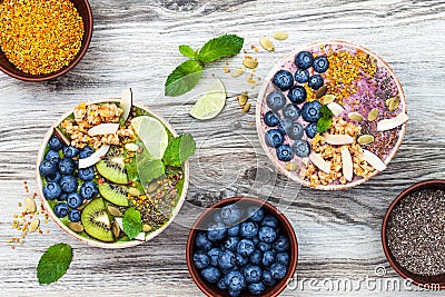 Acai and matcha green tea breakfast superfoods smoothies bowls topped with chia, flax and pumpkin seeds, bee pollen, granola Stock Photo