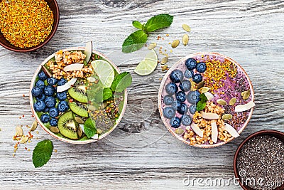 Acai and matcha green tea breakfast superfoods smoothies bowls topped with chia, flax and pumpkin seeds, bee pollen, granola Stock Photo