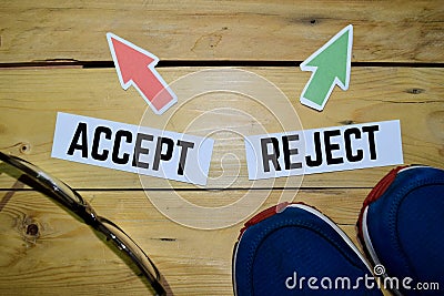 Accept or Reject opposite direction signs with boots, eyeglasse and sneakers on wooden Stock Photo