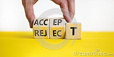 Accept or reject symbol. Businessman turns wooden cubes and changes the word reject to accept. Beautiful yellow table, white Stock Photo