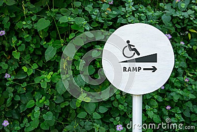 Accessibility in city public park, Sign board of Ramp for Disabled people or handicapped, Natural green leaf as backdrop wall Stock Photo