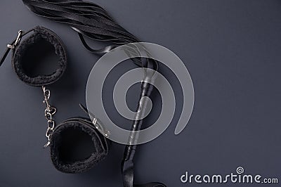 Accessories for bdsm on a black background. Leather lash and leather handcuffs. Valentine`s Day. Erotic shop. Copy space Stock Photo
