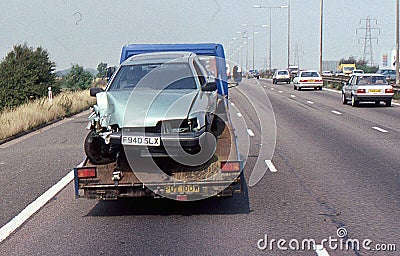 Accident damaged car on the back of a truck Editorial Stock Photo