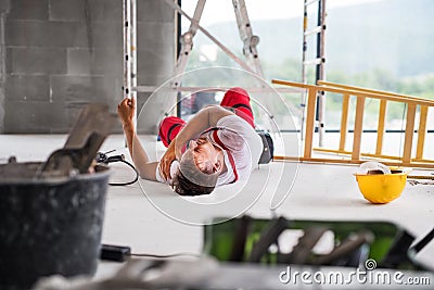 An accident of a man worker at the construction site. Stock Photo