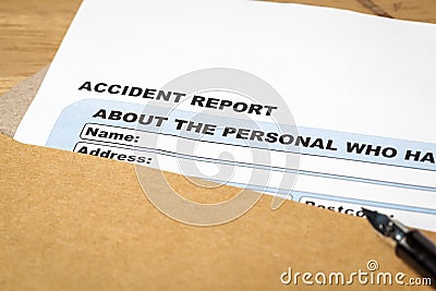 Accident report application form and pen on brown envelope, business insurance and risk concept; document is mock-up Stock Photo