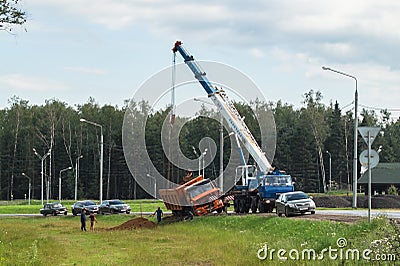 Aâ€‚boom truck hooking and lifting an overturned lorry, Moscow suburbs, Russia. Editorial Stock Photo
