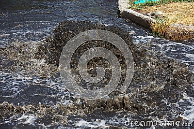 Accident sewerage system. Water flows over the road from sewer. Accident in sewer. Breakthrough sewerage system. Water flows out o Stock Photo