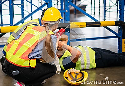 Accident at work concepts, Foreman workers taking care about their colleague lying on the floor in a warehouse Stock Photo