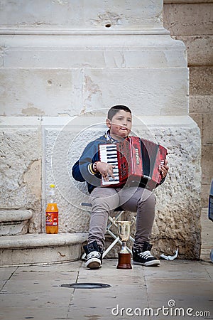 Accordion player, poor child busker Editorial Stock Photo
