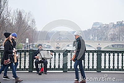 Accordionist plating accordion on the Arcole bridge in Paris, over the Seine river Editorial Stock Photo