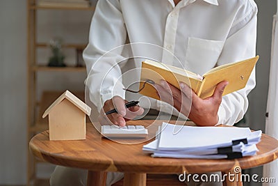 Accountant, businessman, real estate agent, Businessman handing model house to customers along with house interest calculation Stock Photo