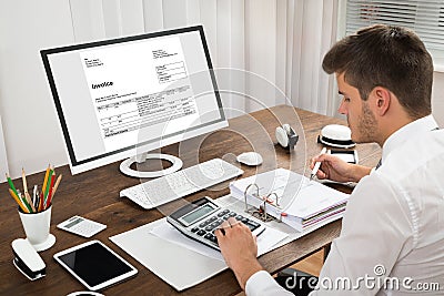 Accountant Calculating Tax At Desk Stock Photo