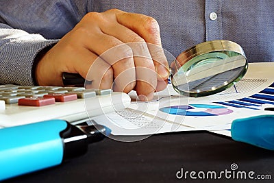 Accountant checking financial report with magnifying glass. Accounting. Stock Photo