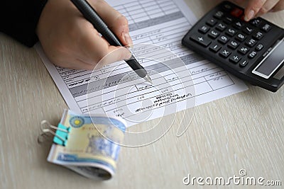 Accountant start to fill Iranian tax form on office table. Taxation period and annual taxpayers routine Editorial Stock Photo