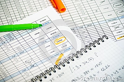 Accounting reports in tables, a paper notebook with profit calculations and highlighters Stock Photo