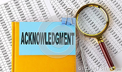 ACKNOWLEDGMENT text on sticker on notebook with magnifier and chart. Business concept Stock Photo