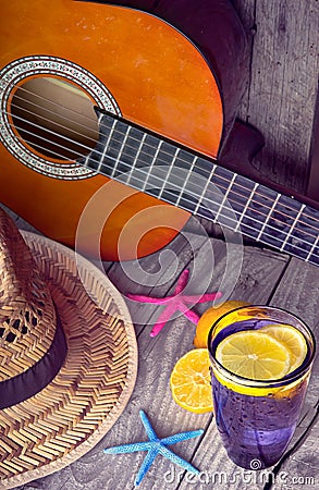 Acoustic guitar hat starfish and glass of tasty fresh lemonade with lemons on vintage wood Stock Photo