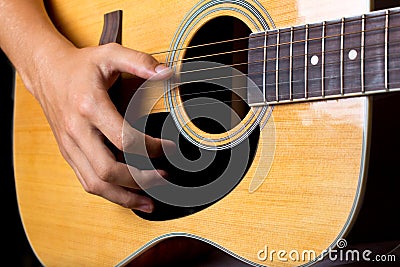 Acoustic guitar man`s hand strumming guitar chords close up photo Stock Photo