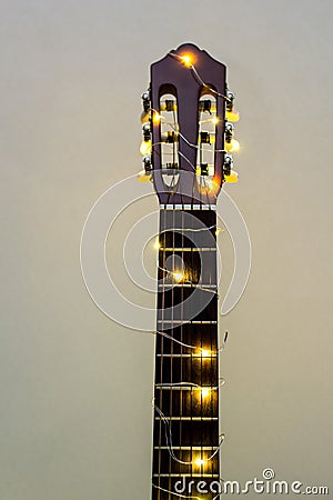 acoustic guitar wrapped in a luminous garland. Christmas gift Stock Photo