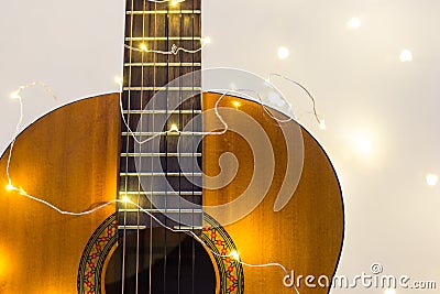 acoustic guitar wrapped in a luminous garland. Christmas gift Stock Photo