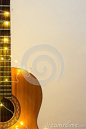 acoustic guitar wrapped in a luminous garland. Christmas gift Stock Photo