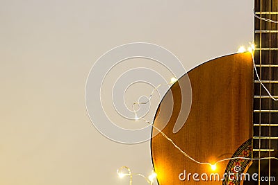 acoustic guitar wrapped in a luminous garland. Christmas gift Stock Photo